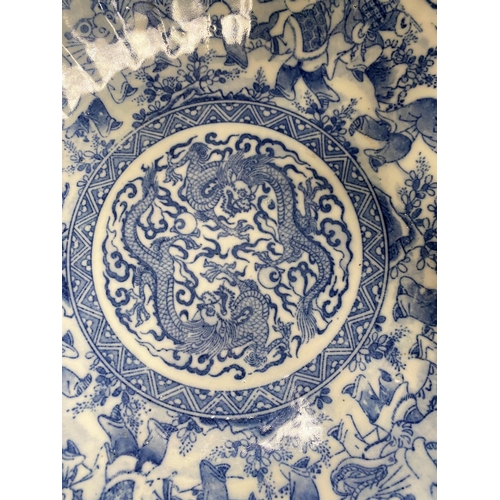 468B - A Chinese shallow blue and white dish with centre dragon figure with wide border; a Chinese dish wit... 