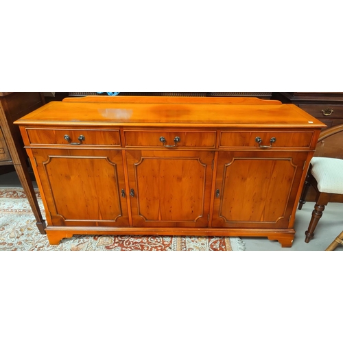 689 - A reproduction Yew wood sideboard with three cupboards and three drawers. Length 150 x 42 x 81cm