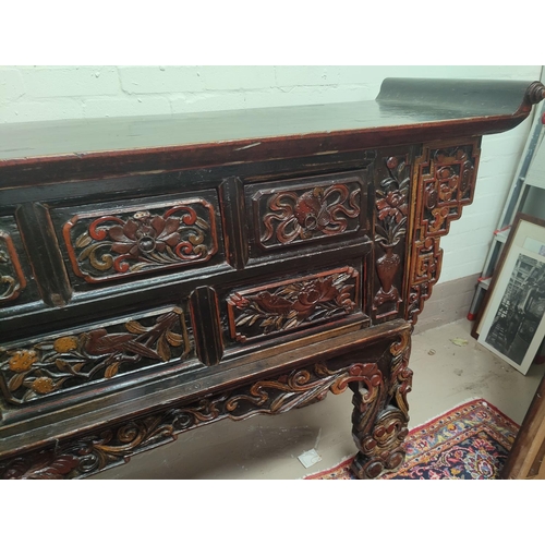 702 - A late 19th/early 20th century Chinese unusual altar table, carved and lacquered with scroll end top... 