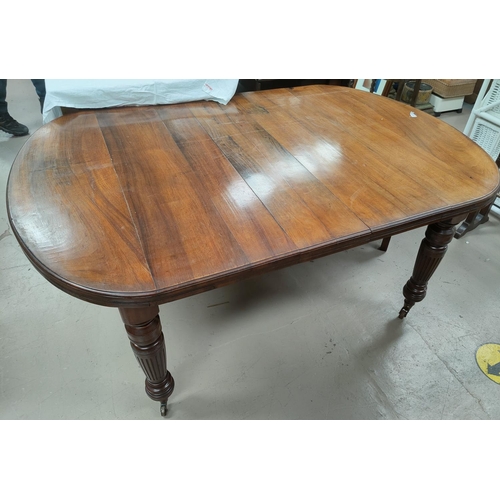 756 - An early 19th century mahogany dining table with extending 'D' end to, on turned fluted legs and cas... 