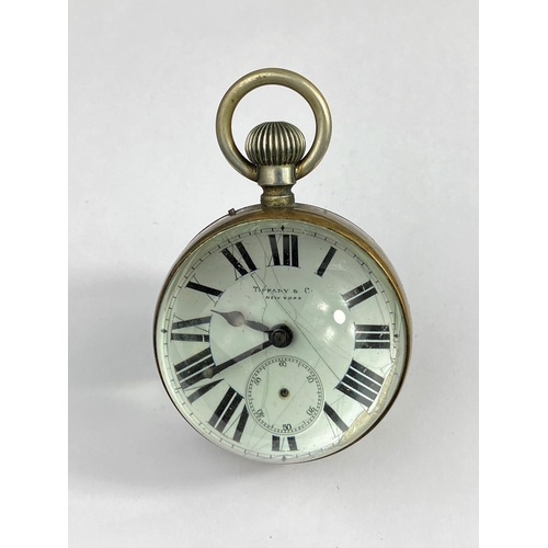502 - A vintage 36 hour 'cricket ball' shaped glass clock with magnifying effect, white dial marked 'Tiffa... 