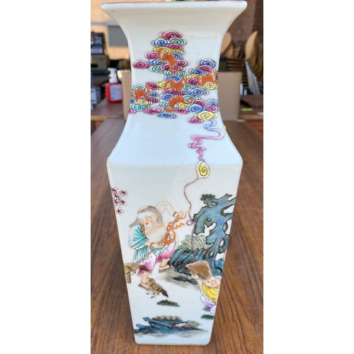 466 - A Chinese square baluster vase famille rose decoration with figures working and/or relaxing with red... 