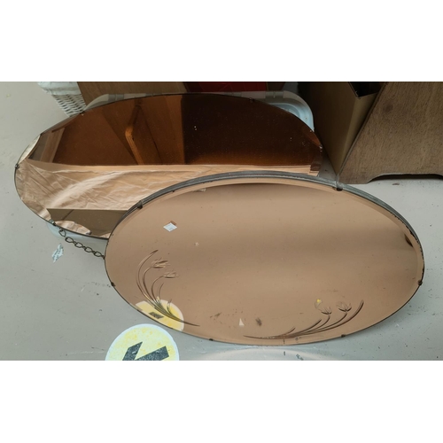 633 - A circular floral etched peach framed wall mirror; an oval peach framed wall mirror