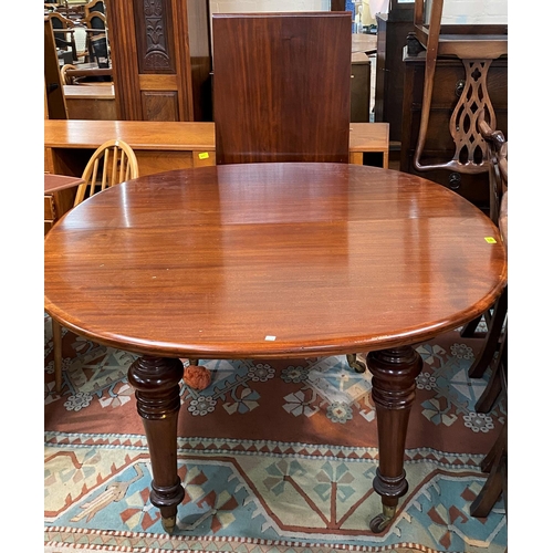 753a - A Victorian dining table with extending oval top, spare leaf, on turned legs and castors, extended l... 