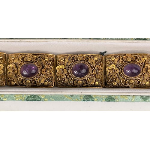509 - A silver gilt filigree bracelet set amethyst coloured cabochon stones; costume jewellery