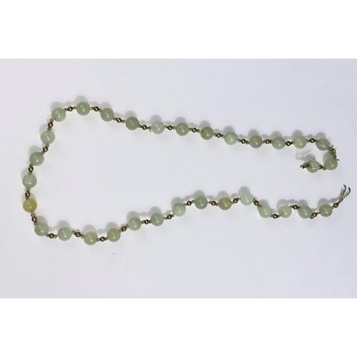 572 - A hardstone 'apple jade' bead necklace