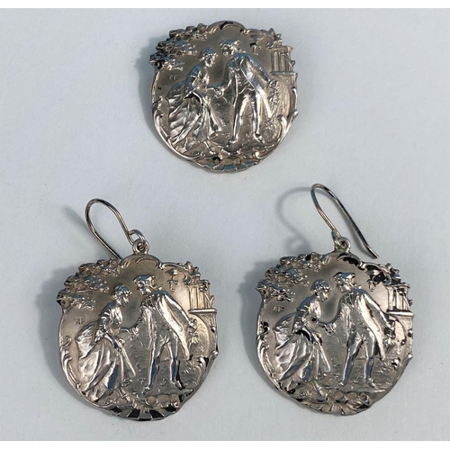 601A - A silver earrings and brooch set, showing an image of an 18th century courting couple, hallmarked Lo... 