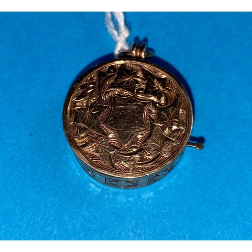 559 - An unusual yellow metal fob set with a roulette wheel with chased decoration, unmarked