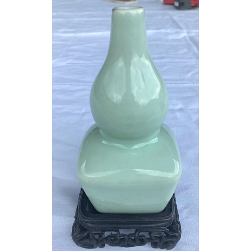 346D - A Chinese celadon glaze double gourd vase with squared base, on wood stand, 6 character mark to base... 