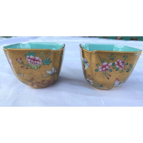 345F - A pair of Chinese squared tea bowls with gilt and polychrome decoration, turquoise interior, red sea... 