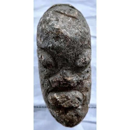 174 - An African carved stone head, eyes, mouth and nose in relief 18cm