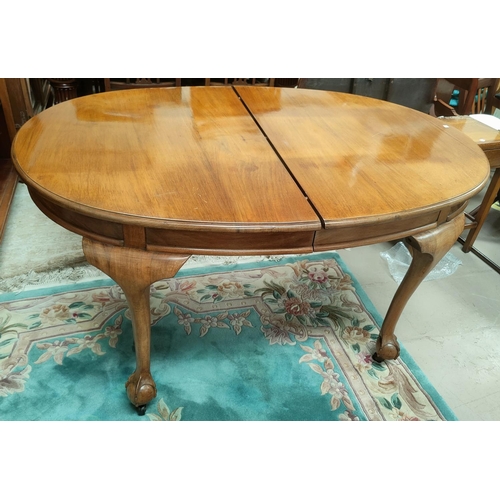 711 - A walnut dining table with oval extending top on cabriole legs and ball and claw feet, 1 leaf, exten... 