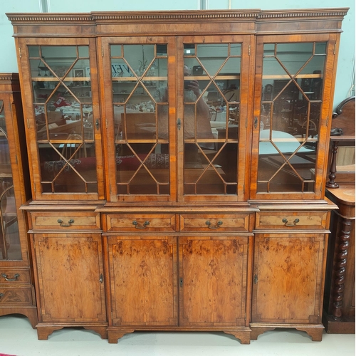 712 - A reproduction yew wood library bookcase with breakfront, 4 astragal glazed door over 4 drawers and ... 