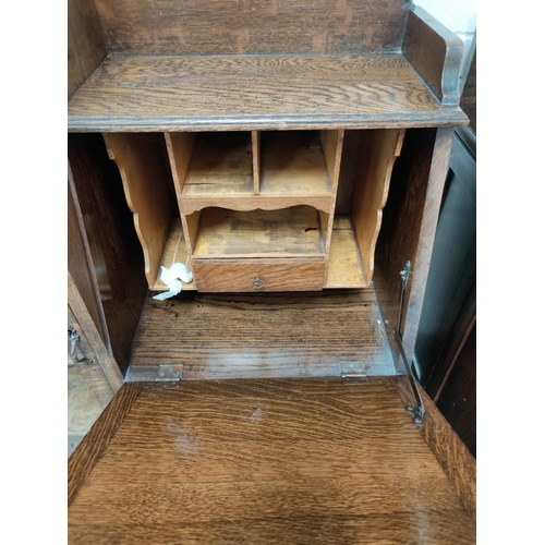 730 - A 1930's oak side by side display cabinet with full length glazed door, cupboard and fall front writ... 