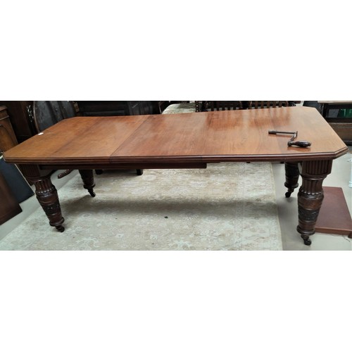 811 - A mahogany canted edge rectangular extending dining table with extra leaf and heavy carved legs with... 