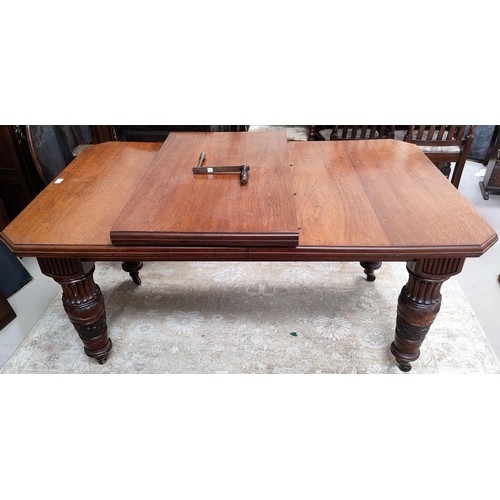 811 - A mahogany canted edge rectangular extending dining table with extra leaf and heavy carved legs with... 