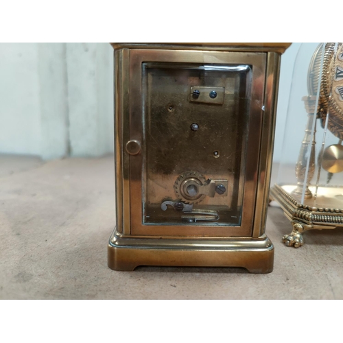 102 - A late 19th century French carriage clock with timepiece movement; a gilt reproduction mantel clock