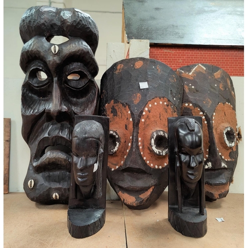 106 - An African large tribal face mask, grotesque carving inset cowrie shells; a pair of hardwood bookend... 