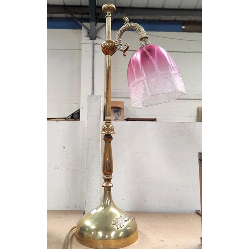 93 - An Edwardian brass desk lamp with cranberry shade