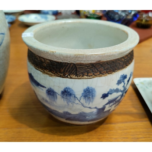 345C - A Chinese blue and white crackle glaze ginger jar showing scholars and with bark effect decoration t... 