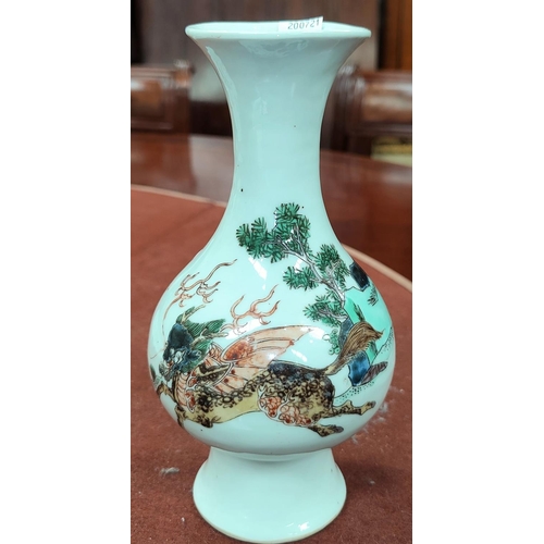 347F - A Chinese famille verte vase depicting mythological creature galloping over trees, height 21cm