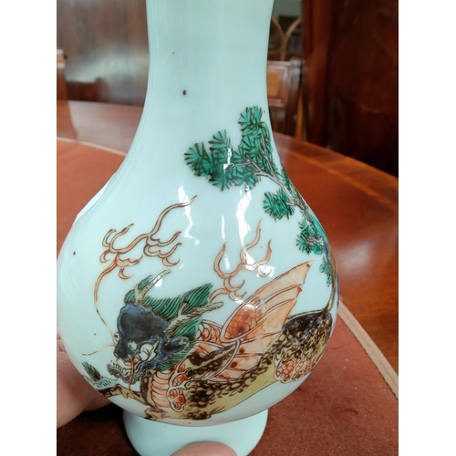 347F - A Chinese famille verte vase depicting mythological creature galloping over trees, height 21cm