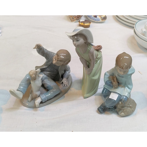 398 - Two Nao figures, boy with dog & boy with rabbit; a Lladro figure, girl in hat