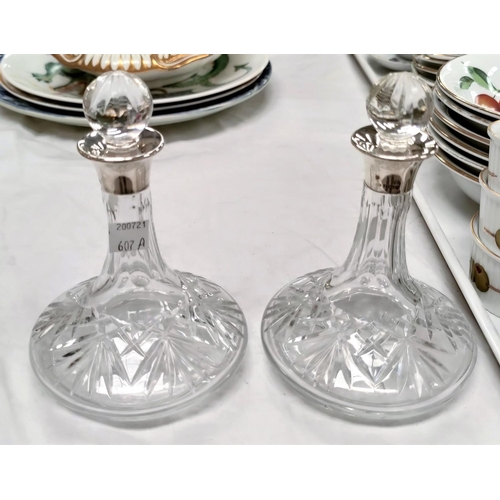 607A - A pair of small cut glass liquor decanters with hallmarked silver collars.  Height 16cm.