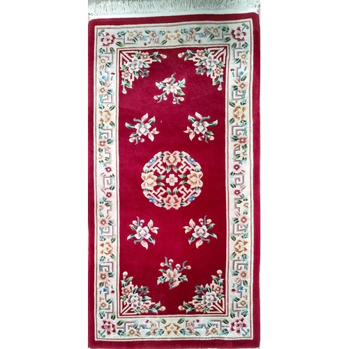 833 - A red ground floral Chinese rug and a gold Chinese rug
