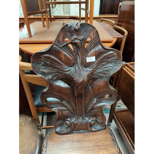 791 - An oak hall chair with finely carved back panel a naturalistic shaped back with pierced sections wit... 