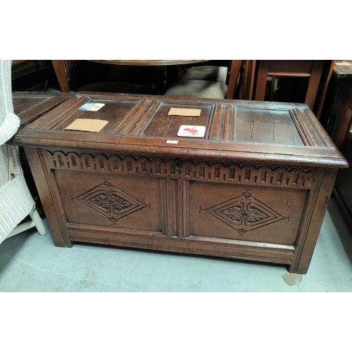 794 - A heavy carved oak coffer with double diamond panels to the front