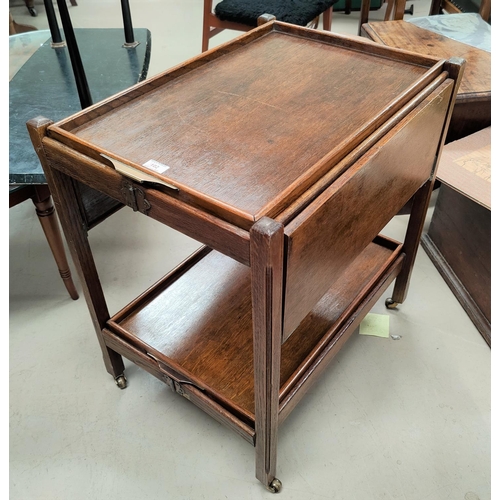 802 - An oak collapsible two height tea trolley on brass castors