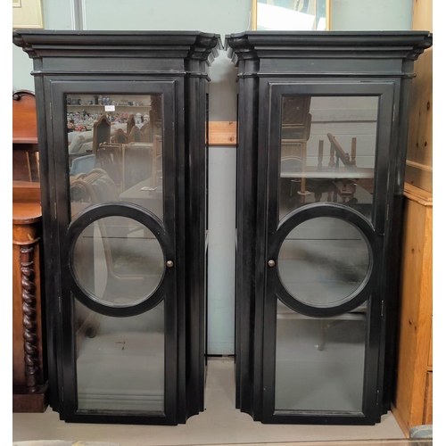 765 - A pair of modern ebonised tall narrow display cabinets with single glazed doors in the French manner... 