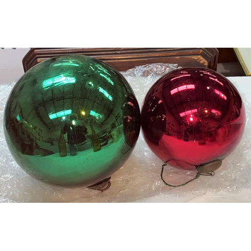 380 - A large 19h century green mirror glass witches ball, 16cm and a similar in red glass