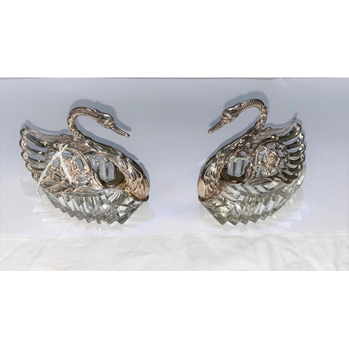 563 - A pair of cut glass swan salts with hallmarked silver heads, necks and wings import marks for London... 