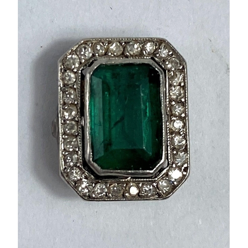 573 - A rectangular cushion cut emerald coloured stone, surrounded by small diamonds.