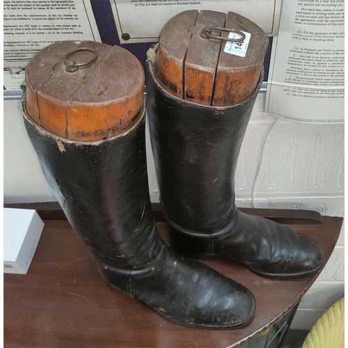 146 - A pair of vintage knee high leather riding boots with wooden shapers inside.