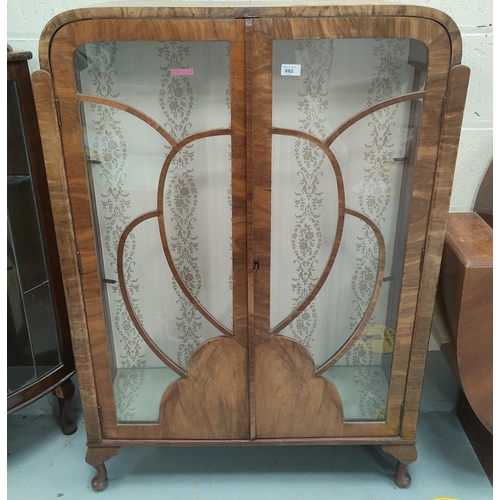 662 - A 1930's walnut china cabinet enclosed by 2 doors