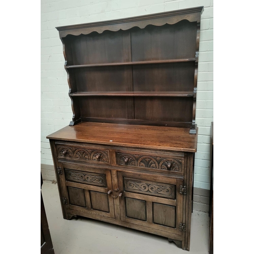 682 - A carved oak reproduction Welsh dresser with 2 height delft rack over 2 drawers and 2 cupboards