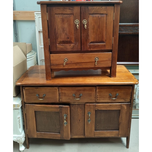 747 - A stained pine side cabinet; a similar smaller cabinet