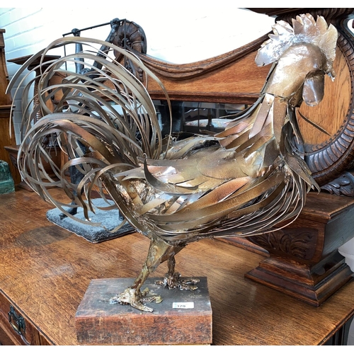 370 - D. Ainsworth: Local artist, a large studio figure of a metal cockerel on a wooden base, height: 57cm... 