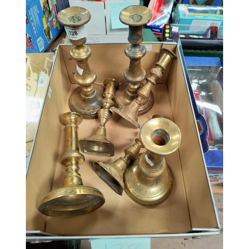 128 - Various brass candlesticks.