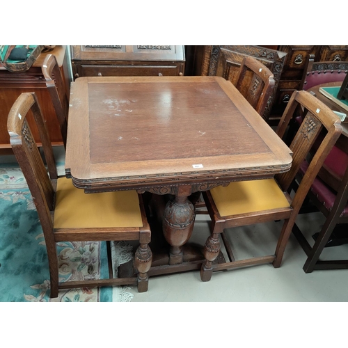661 - A 1930's carved oak dining suite comprising draw-leaf dining table (a.f.underneath), 4 chairs