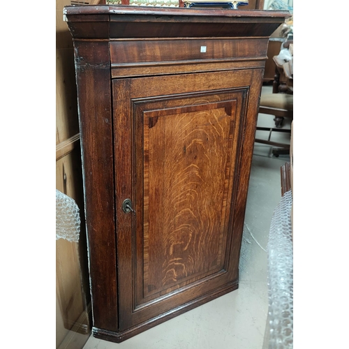 683 - A Georgian crossbanded oak corner cupboard with straight front enclosed by single door