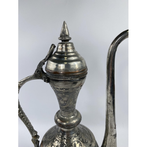 576 - A Middle Eastern silver on copper teapot ewer with animal decoration etc ht 34cm and a brass and cop... 