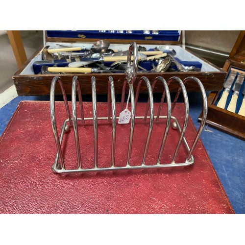 583 - A large silver plate toast rack; a red cased selection of fish servers, other boxed and loose cutler... 