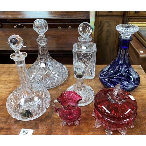 435 - A blue overlaid glass decanter; 3 others; a cranberry covered bowl; etc.