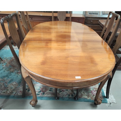 721 - An oval walnut extending dining table with 1 spare leaf, extended length 180cm and set of four mahog... 