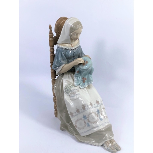 432 - A large Lladro group:  seated girl with embroidery, height 30 cm