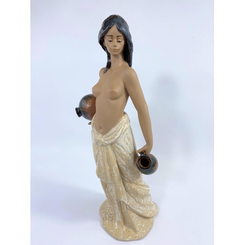 444 - A Lladro bisque  figure:  female water carrier, bare breasted, height 36 cm